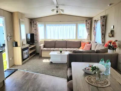 a living room with a couch and a table at St Osyth- Sleeps8-freeparking-wifi-holidaypark in Clacton-on-Sea