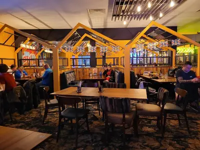a restaurant with wooden tables and people sitting at tables at St Osyth- Sleeps8-freeparking-wifi-holidaypark in Clacton-on-Sea
