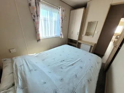 a bedroom with a bed in a room with a window at St Osyth- Sleeps8-freeparking-wifi-holidaypark in Clacton-on-Sea