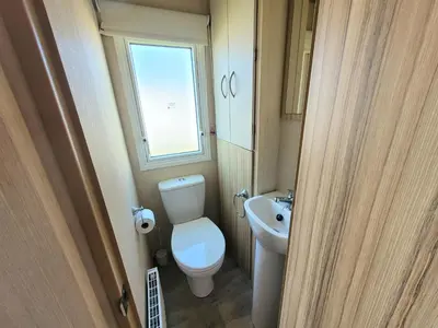 a small bathroom with a toilet and a sink at St Osyth- Sleeps8-freeparking-wifi-holidaypark in Clacton-on-Sea