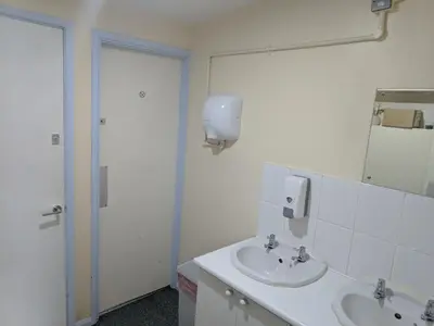 a white bathroom with a sink and a mirror at HARLOW INTERNATIONAL HOSTEL in Harlow