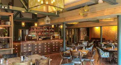 a restaurant with tables and chairs and a bar at Guinness Arms in Icklingham