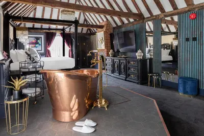a large bathroom with a tub and a bed at Staycations Maldon in Maldon