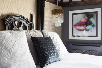 a bedroom with a white bed with a picture on the wall at Staycations Maldon in Maldon