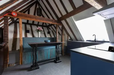 a kitchen with a table and a bench in a room at Staycations Maldon in Maldon