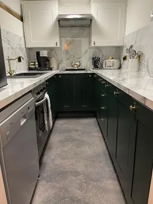 a kitchen with green cabinets and white counter tops at Staycations Maldon in Maldon