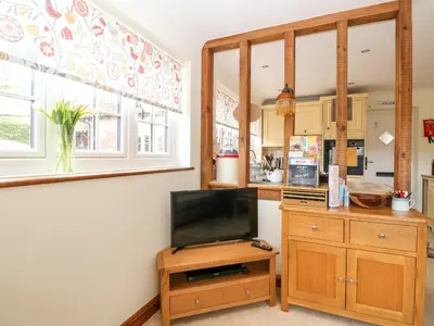 a kitchen with a tv on a wooden stand with a tvictericterigunigun at Hunters Lodge in Norwich