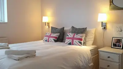 a bedroom with a white bed with pillows on it at Island Retreat with HotTub in West Mersea