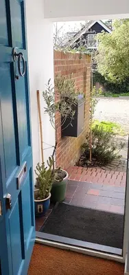 an open door with potted plants on a patio at Island Retreat with HotTub in West Mersea
