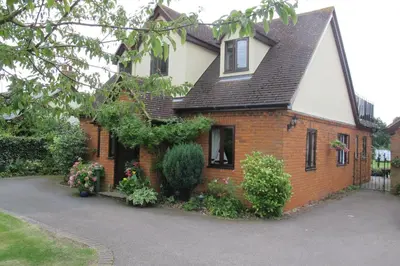 a brick house with a black roof at Burnt Mill Cottage in Burnham on Crouch