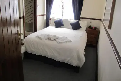 a bedroom with a bed with towels on it at Burnt Mill Cottage in Burnham on Crouch
