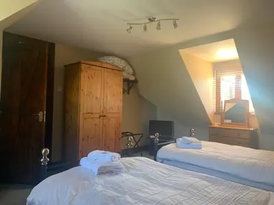 a bedroom with two beds with towels on them at Burnt Mill Cottage in Burnham on Crouch