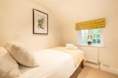 a bedroom with a white bed and a window at 1 Chantry Cottage in Tunstall