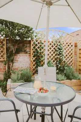 a table with a bowl of fruit and an umbrella at 1 Chantry Cottage in Tunstall