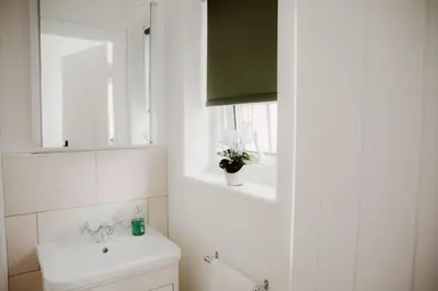 a bathroom with a toilet and a sink and a window at 1 Chantry Cottage in Tunstall