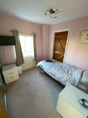 a bedroom with a bed and a window at Carlton Cottage Country Retreat - Perfect for Ipswich - Aldeburgh - Southwold - Thorpeness - Sizewell B - Sizewell C - Sleeps 13 in Little Glenham