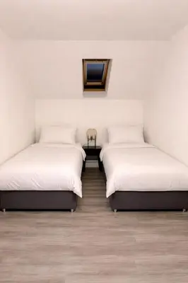 three beds in a room with white walls and wooden floors at Modern Spacious Flat In Ipswich - Sleeps 6 - Parking in Freston