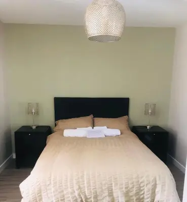 a bedroom with a large bed with two night stands at The Annexe II in Mildenhall
