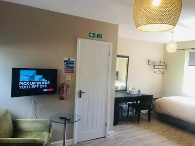 a room with a bed and a room with a desk at The Annexe II in Mildenhall