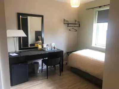 a bedroom with a desk and a bed and a mirror at The Annexe II in Mildenhall