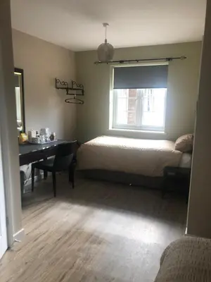 a bedroom with a bed and a desk and a window at The Annexe II in Mildenhall