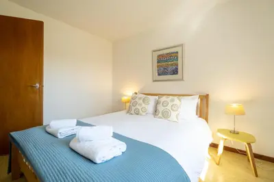 a bedroom with a bed with towels on it at Sea Poppies in Thorpeness