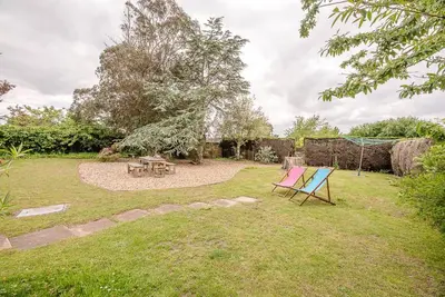 a garden with a table and a picnic table at Sea Poppies in Thorpeness
