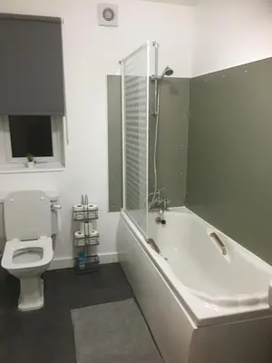 a bathroom with a white tub and a toilet at Stone Cottage in Nazeing