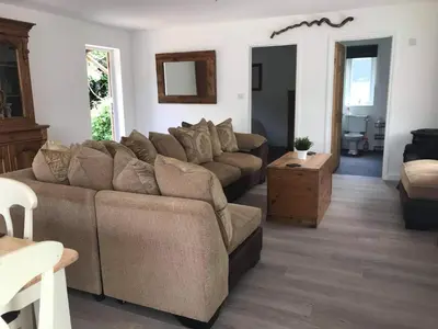 a living room with a couch and a table at Stone Cottage in Nazeing