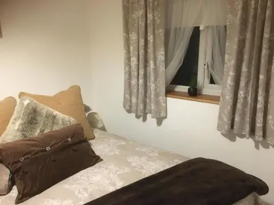 a bed with two pillows and a window at Stone Cottage in Nazeing