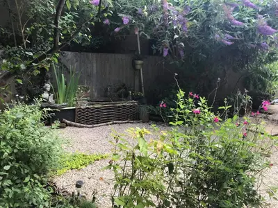 a garden with a fence and some flowers at Stone Cottage in Nazeing