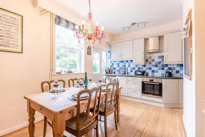 a kitchen with a table and chairs and a chandelier at Settled In, Aldeburgh in Aldeburgh