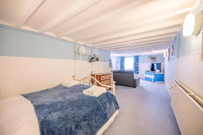 a bedroom with a bed and a living room at Settled In, Aldeburgh in Aldeburgh