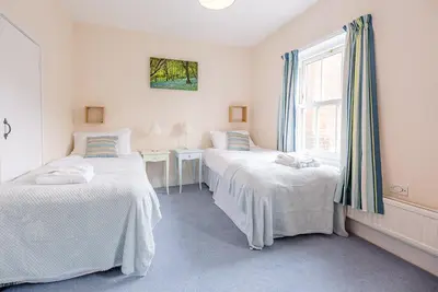 two beds in a room with a window at Settled In, Aldeburgh in Aldeburgh