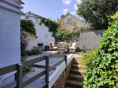a patio with chairs and a table in a backyard at Settled In, Aldeburgh in Aldeburgh
