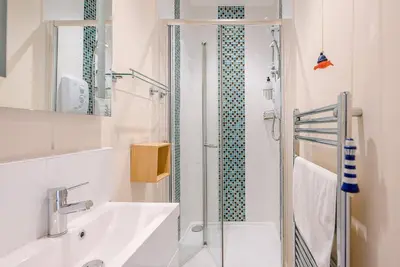 a white bathroom with a shower and a sink at Settled In, Aldeburgh in Aldeburgh