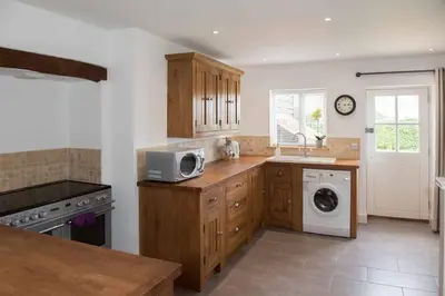 a kitchen with a sink and a microwave at Immaculate barn annexe close to Stansted Airport in Great Dunmow