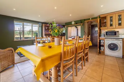 a kitchen and dining room with a table and chairs at The Granary, Dunstall Green in Denham