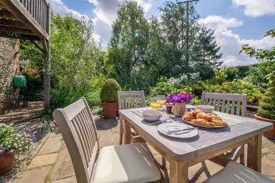 a wooden table with a plate of food on it at The Granary, Dunstall Green in Denham