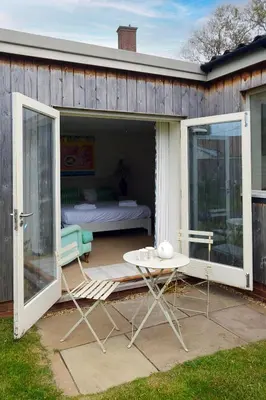 a patio with a bed and a table and a bed at Winton Lodge in Aldeburgh