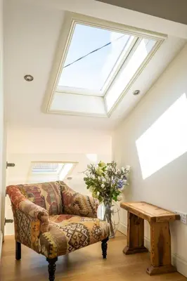 a living room with a couch and a skylight at Winton Lodge in Aldeburgh