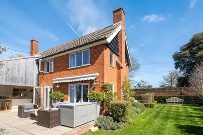 a brick house with a garden in front of it at Winton Lodge in Aldeburgh