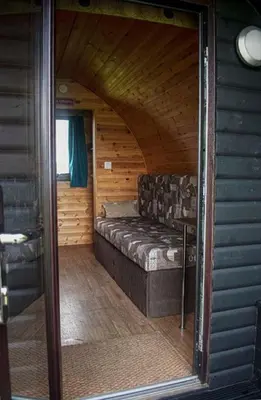 a living room with a couch in a log cabin at Rockinghams Farm in Layer Marney