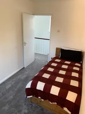 a bedroom with a bed with a brown and white blanket at 5 Bedroom House with outdoor space in Upminster