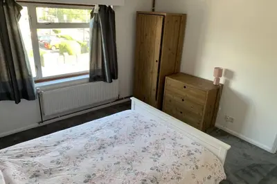 a bedroom with a bed and a window and a dresser at 5 Bedroom House with outdoor space in Upminster
