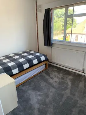 a small room with a bed and a window at 5 Bedroom House with outdoor space in Upminster