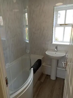a bathroom with a tub and a sink at Grant Close in Wickford