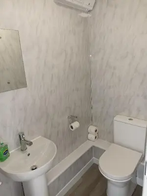 a white bathroom with a sink and a toilet at Grant Close in Wickford