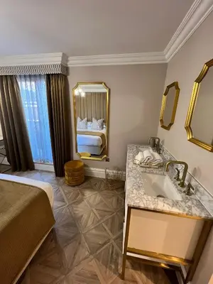 a bathroom with a bed and a sink and a mirror at The Kings Head in Chelmsford