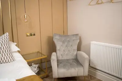 a living room with a chair and a bed at The Kings Head in Chelmsford